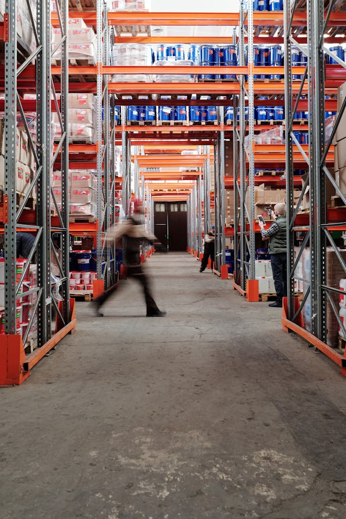 Industrial warehouse with shelves and a moving worker, showcasing organized storage.